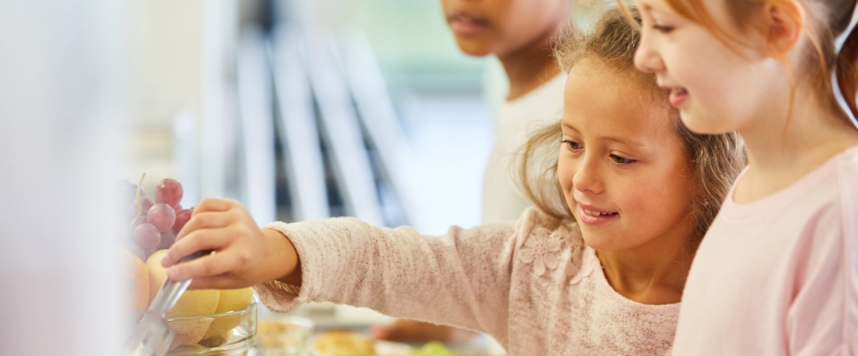 Kinder holen Essen am Büffet der Cafeteria in Kindergarten oder Grundschule